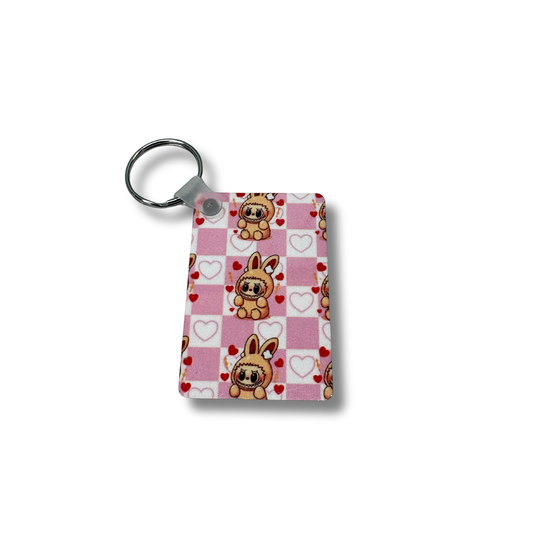 Keychain with cartoon dog design on a pink checkered background